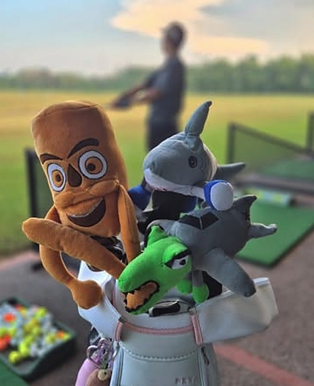 A group of Golfpanions plush headcovers on a golf bag